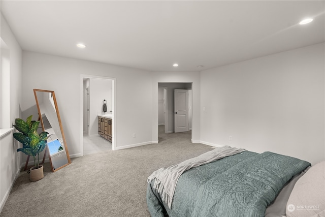 bedroom featuring ensuite bath and light carpet