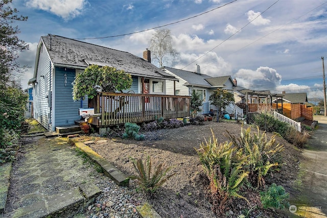 back of property with a chimney, a wooden deck, and a pergola