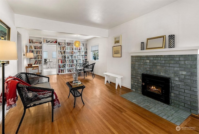 living room featuring hardwood / wood-style floors and a brick fireplace