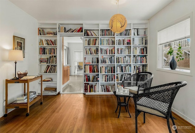 sitting room with hardwood / wood-style floors and built in features