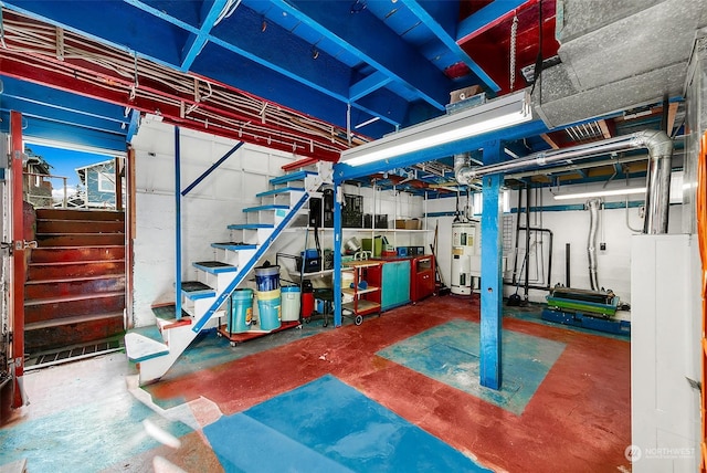 unfinished basement with stairway and electric water heater