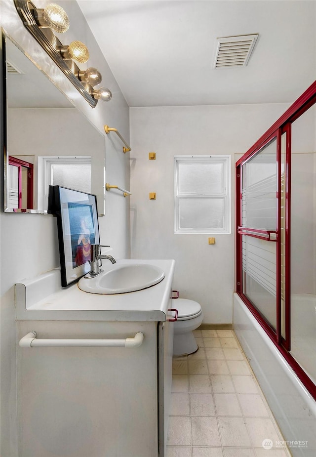 full bathroom featuring visible vents, toilet, shower / bath combination with glass door, tile patterned floors, and vanity