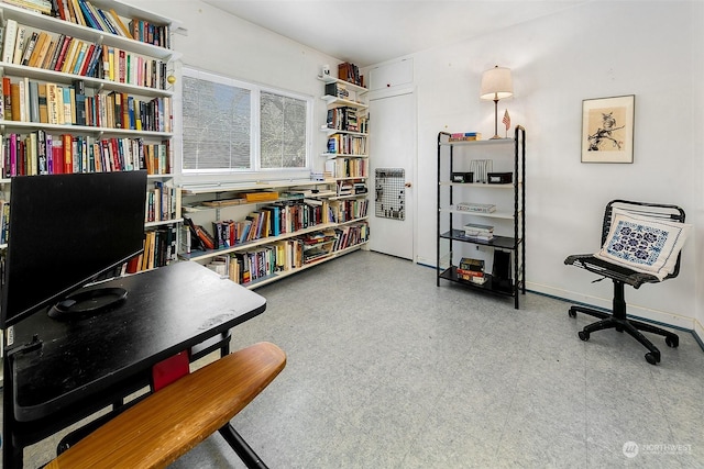 office space with baseboards and light floors