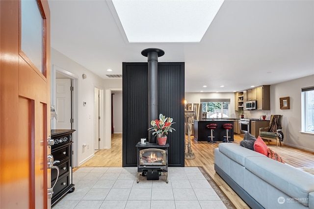 living room featuring light hardwood / wood-style floors and a wood stove