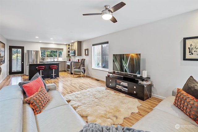 living room with ceiling fan and light hardwood / wood-style floors