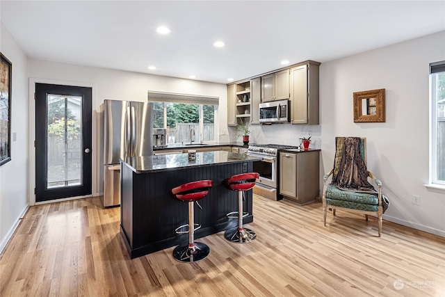 kitchen featuring a center island, sink, stainless steel appliances, and light hardwood / wood-style flooring