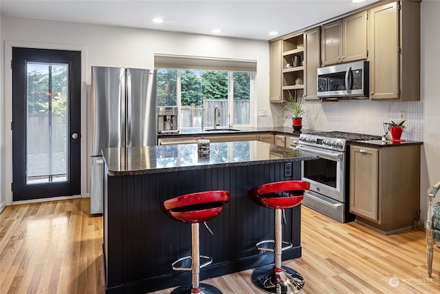 kitchen featuring a breakfast bar, a kitchen island, sink, and stainless steel appliances