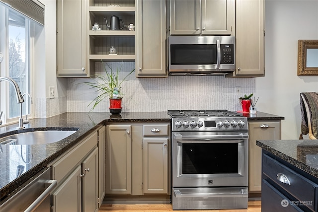 kitchen featuring gray cabinetry, sink, dark stone countertops, appliances with stainless steel finishes, and tasteful backsplash