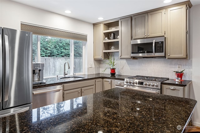 kitchen with sink, dark stone counters, and appliances with stainless steel finishes