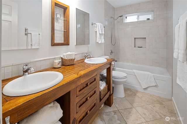 full bathroom featuring vanity, tiled shower / bath combo, and toilet