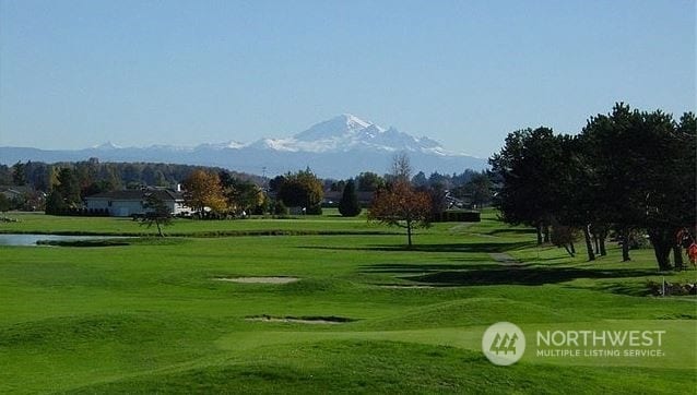 surrounding community with a mountain view and a yard