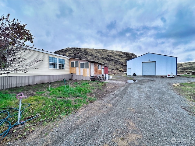 view of front of property featuring a mountain view, an outbuilding, and a garage