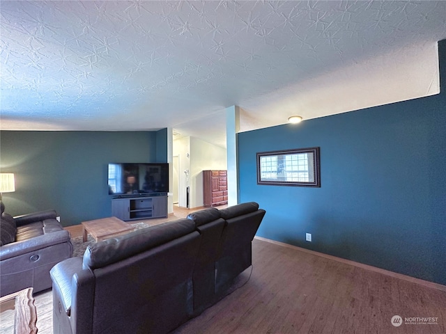 living room with a textured ceiling, lofted ceiling, and hardwood / wood-style flooring