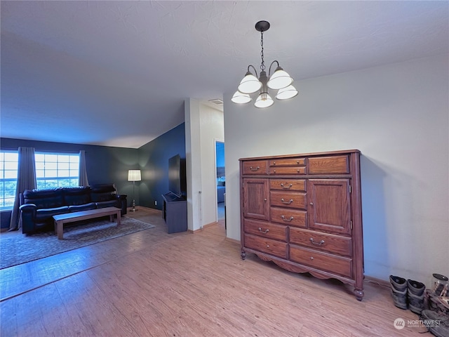 interior space with light wood-type flooring and an inviting chandelier