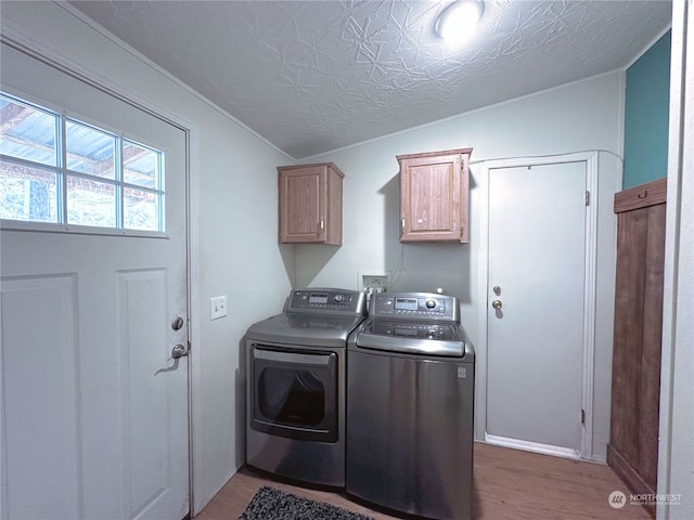 clothes washing area featuring hardwood / wood-style floors, cabinets, independent washer and dryer, a textured ceiling, and ornamental molding