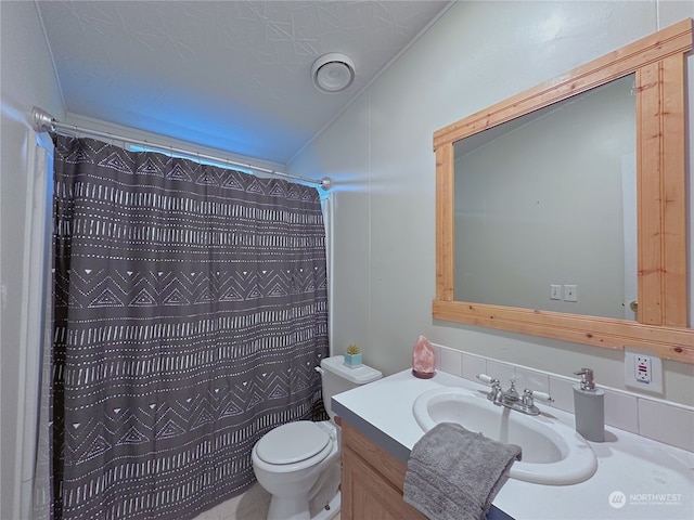 bathroom featuring curtained shower, vanity, and toilet