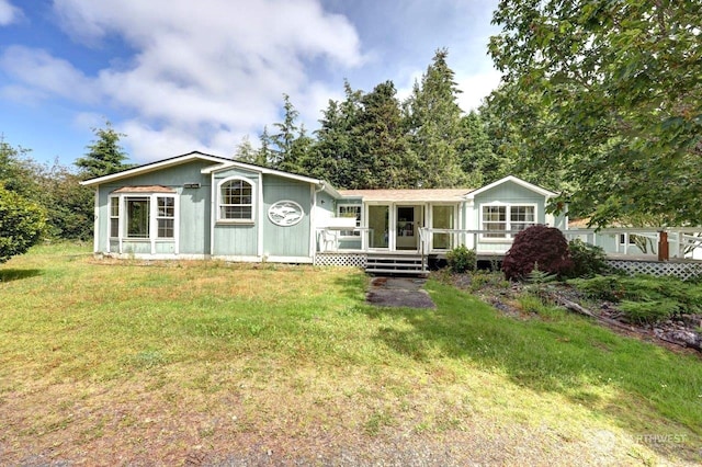 view of front of property featuring a deck and a front lawn