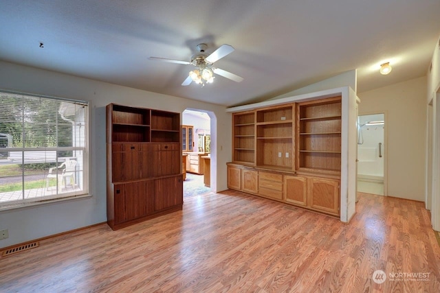 unfurnished living room featuring ceiling fan, a healthy amount of sunlight, light wood-type flooring, and lofted ceiling