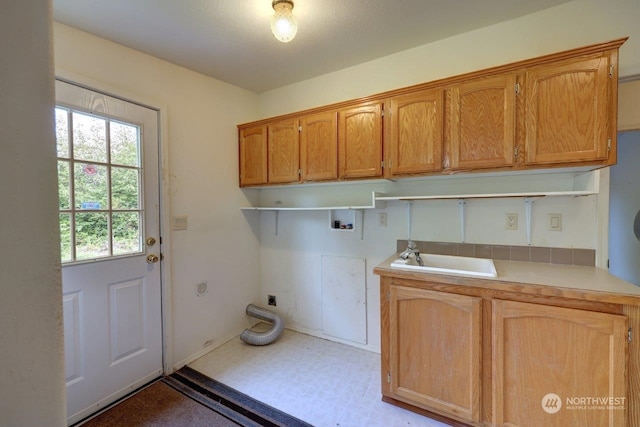 laundry area featuring electric dryer hookup, sink, cabinets, and washer hookup