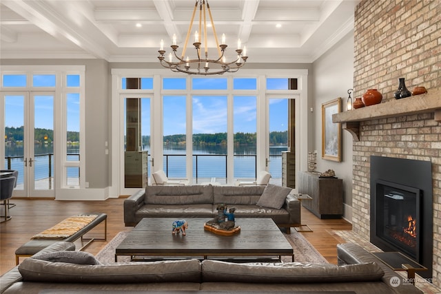 living room featuring a water view, a towering ceiling, a fireplace, and hardwood / wood-style floors