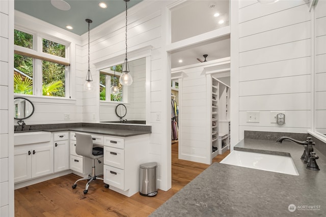 bathroom with crown molding, wood-type flooring, and vanity