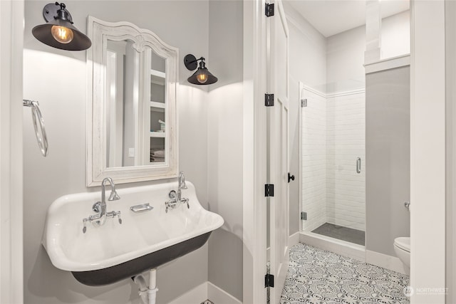 bathroom featuring sink, an enclosed shower, tile patterned floors, and toilet