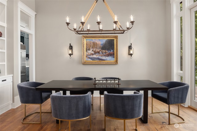 dining space featuring an inviting chandelier and light hardwood / wood-style floors