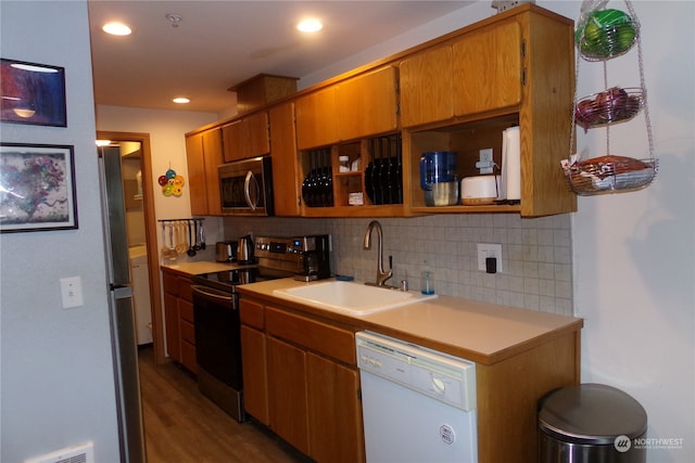 kitchen featuring wood-type flooring, stainless steel appliances, tasteful backsplash, and sink