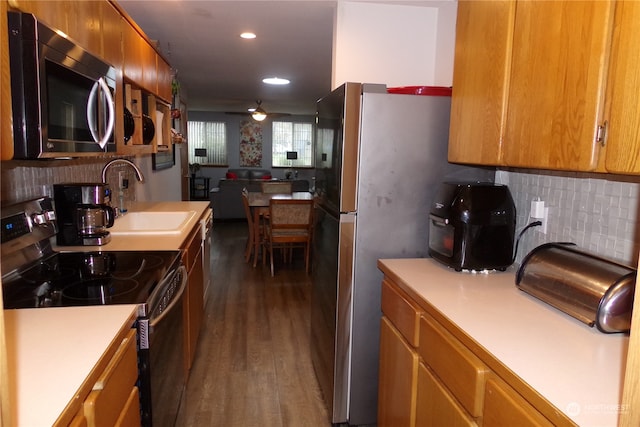 kitchen with black electric range oven, dark wood-type flooring, sink, ceiling fan, and decorative backsplash