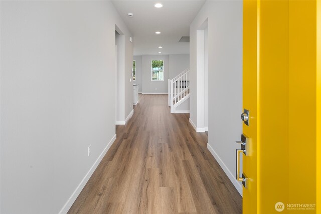 hall featuring wood finished floors, stairway, recessed lighting, and baseboards