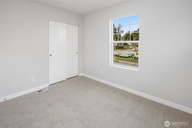 unfurnished bedroom with a closet, baseboards, visible vents, and carpet floors