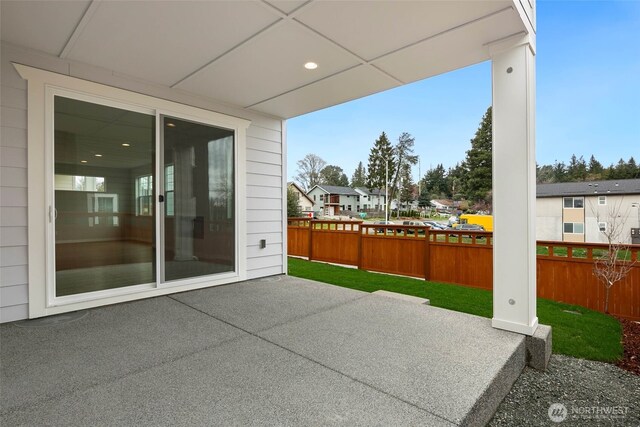 view of patio with fence and a residential view