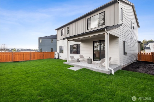 rear view of house featuring board and batten siding, fence, a patio, and a lawn