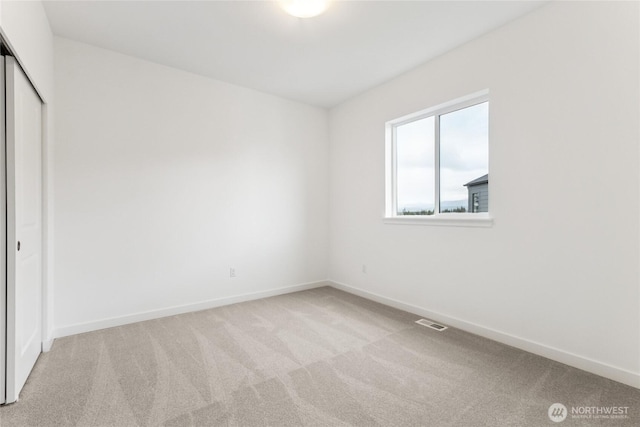 unfurnished bedroom with baseboards, carpet, and visible vents