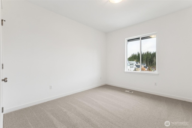 empty room featuring visible vents, baseboards, and carpet