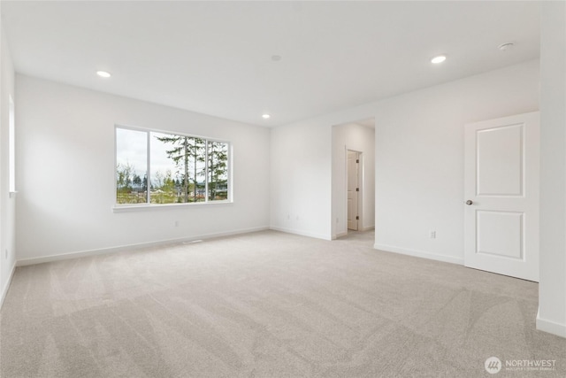 empty room with baseboards, recessed lighting, and light colored carpet