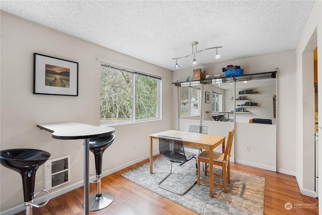 dining room with hardwood / wood-style floors and a textured ceiling