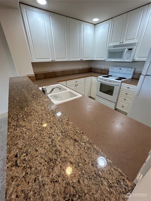 kitchen featuring white cabinets, white appliances, and sink