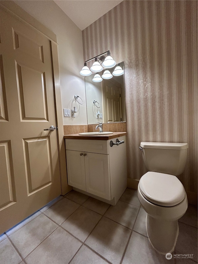 bathroom with tile patterned flooring, vanity, and toilet