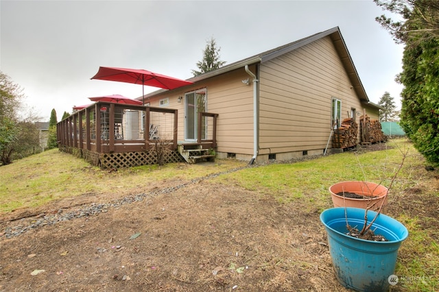 rear view of house with a yard and a wooden deck