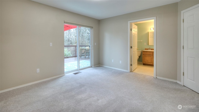 unfurnished bedroom featuring access to outside, ensuite bath, light carpet, and sink