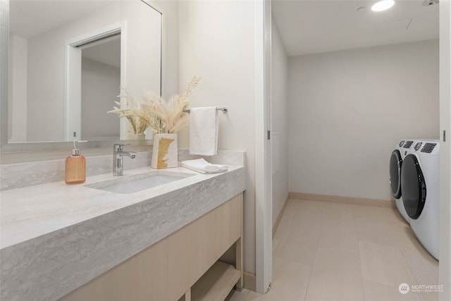 bathroom featuring washer and clothes dryer, vanity, and tile patterned floors