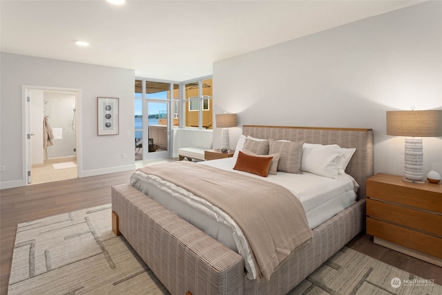 bedroom with light wood-type flooring and connected bathroom