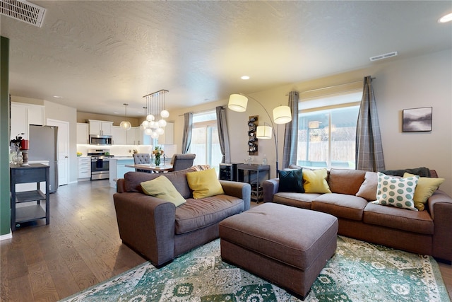 living room with plenty of natural light, wood-type flooring, and a textured ceiling