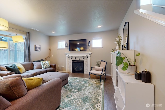 living room with a textured ceiling, a fireplace, and dark hardwood / wood-style floors