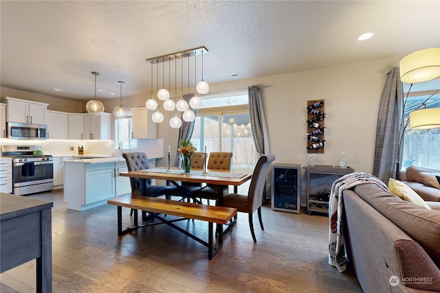 dining area with dark hardwood / wood-style flooring, beverage cooler, and sink