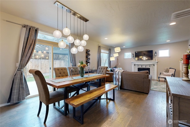 dining space featuring a healthy amount of sunlight and dark wood-type flooring