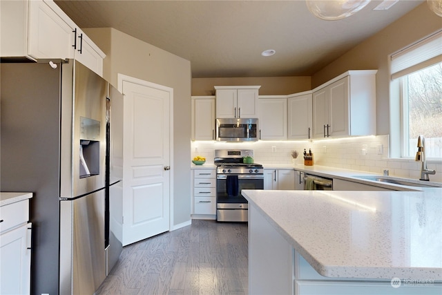 kitchen with white cabinetry, hardwood / wood-style floors, sink, and appliances with stainless steel finishes