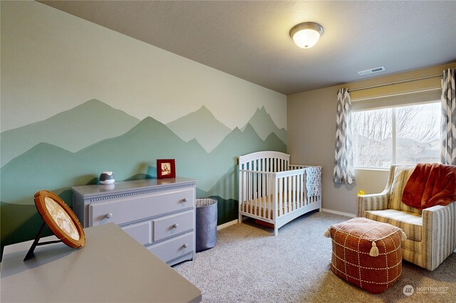 carpeted bedroom with a nursery area