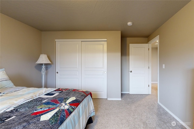 bedroom featuring light carpet and a closet